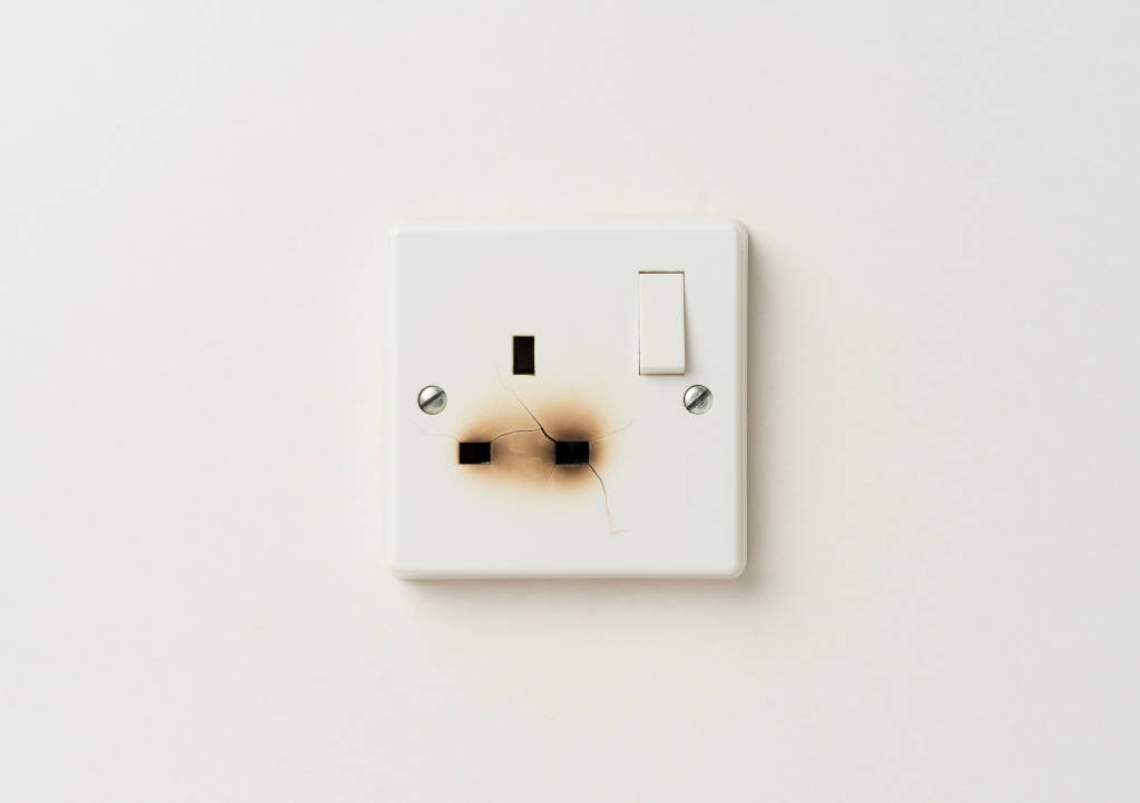 Damaged,Electrical,Domestic,Power,Socket,With,Cracks,And,Burn,Marks